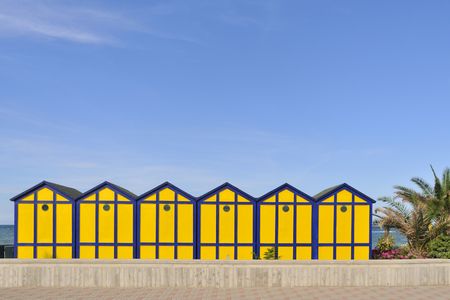Blue and yellow wooden cabins at the beachの写真素材