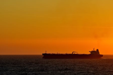 cargo ship by sunset at the oceanの写真素材