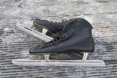 Black skates in the snowの写真素材