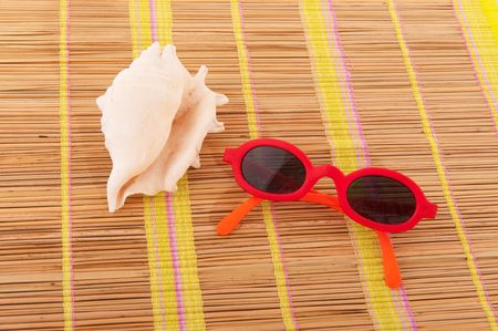 summertime with sunglasses and shell on bambooの写真素材