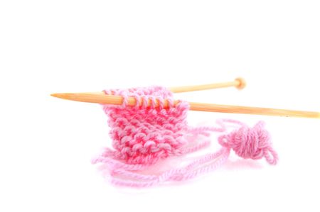 Knitting with pink wool and wooden needlesの写真素材