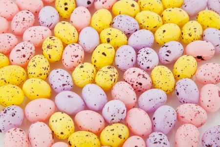 many colorful easter eggs in yellow pink and purple