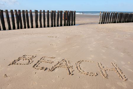 Beach with wooden weave breakers in landscapeの写真素材