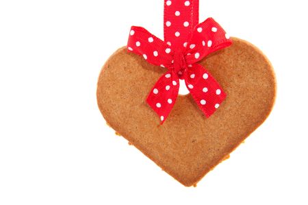 Baked gingerbread heart coookie with red speckles bows and ribbonの写真素材