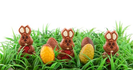 Easter hares in the grass with chocolate eggs