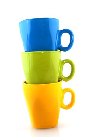 stacked colorful mugs for drinking coffee on whiteの写真素材