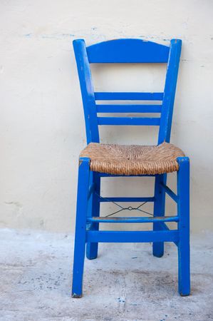 Typical blue Greek chair in front of a white wallの写真素材