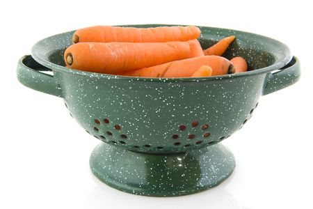 Green colander with fresh carrots on white backgroundの写真素材