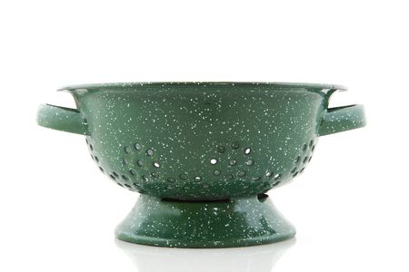Green colander with speckless isolated over whiteの写真素材