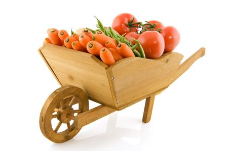 Wooden wheelbarrow filled with fresh vegetables on white backgroundの写真素材