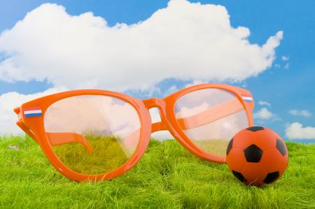 Dutch soccer with orange ball and glasses in grassの写真素材