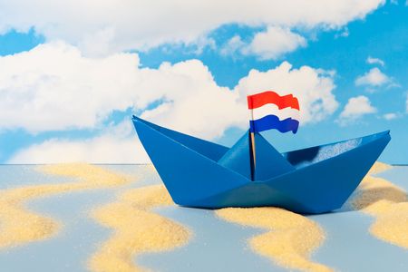 Dutch blue paper boat in landscape with cloudsの写真素材