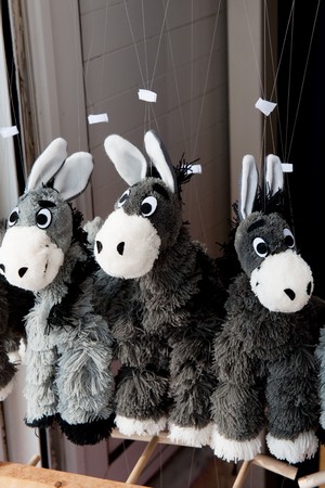 Souvenir donkeys in gray hanging near the shopsの写真素材