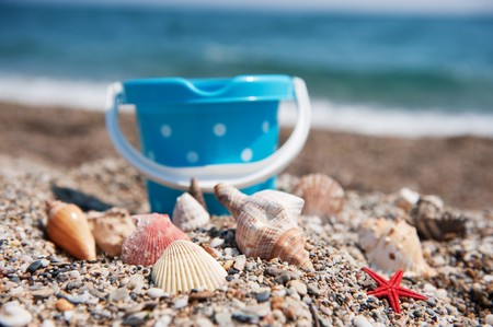 Many shells and toys at the summer beachの写真素材