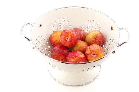 Several healthy fresh plums in white colander to wash themの写真素材