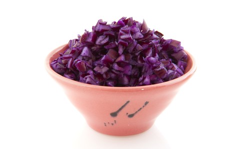 Cut red cabbage in pink bowl isolated over whiteの写真素材