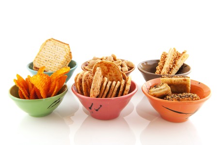 Little bowls with different salted snacks isolated over whiteの写真素材