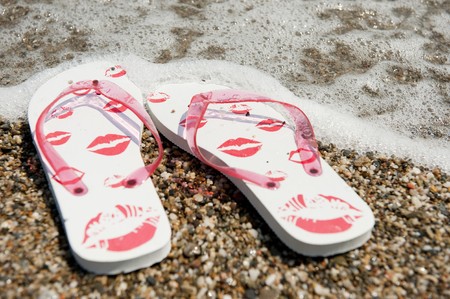 flip flops in the water line at the beachの写真素材