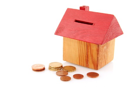 Buying a house with coins isolated over whiteの写真素材