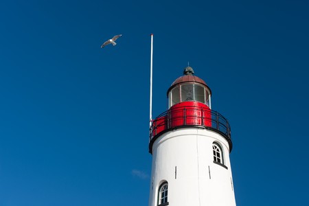 White lighthouse in little Dutch fishing village Urkの写真素材
