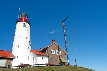 White lighthouse in little Dutch fishing village Urkの写真素材