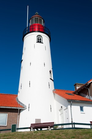 White lighthouse in little Dutch fishing village Urkの写真素材