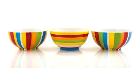 Row with three colorful striped bowls isolated over white の写真素材