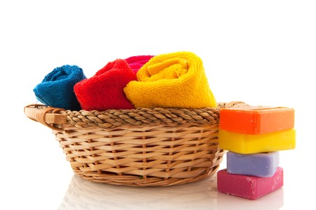 Basket with rolled towels soap and rosesの写真素材