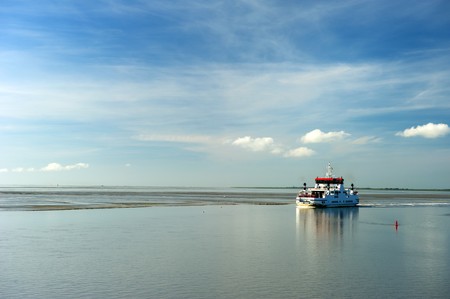 Ferry boat at wadden sea during ebb tidalの写真素材