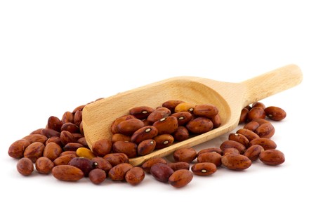 Pinto beans on wooden spoons isolated over white