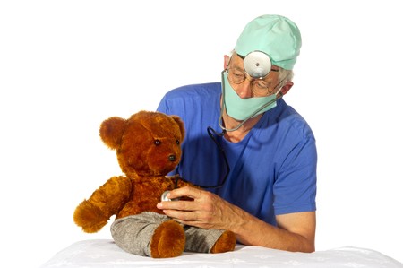 Doctor is having a medical treatment with stethoscope by toy bearの写真素材
