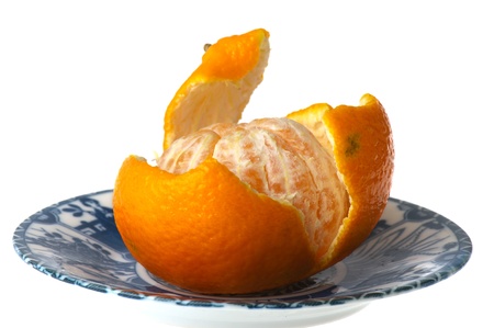 Open tangerine on blue plate isolated over white backgroundの写真素材