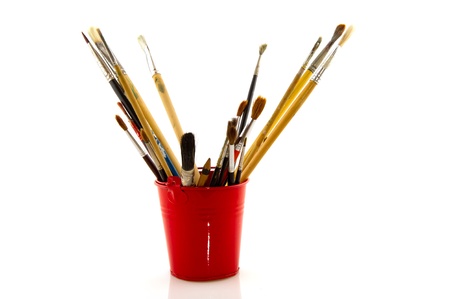 Paint brushes in red little bucket isolated over white backgroundの写真素材