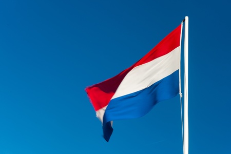 Dutch flag on pole waving in the wind の写真素材