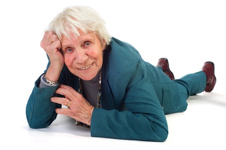 Elderly woman is smiling and laying at the floorの写真素材