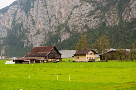 Farm house in Switzerland with pastures and mountainsの写真素材