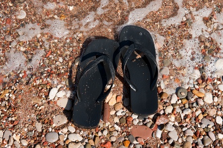 Black flip flops at the summer beachの写真素材