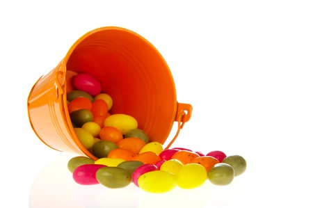 Fallen orange bucket with candy easter eggsの写真素材