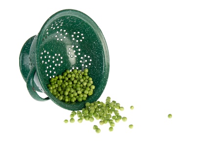 Washing green peas in a colander on white backgroundの写真素材