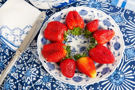 Blue crockery and fresh strawberries at the tableの写真素材