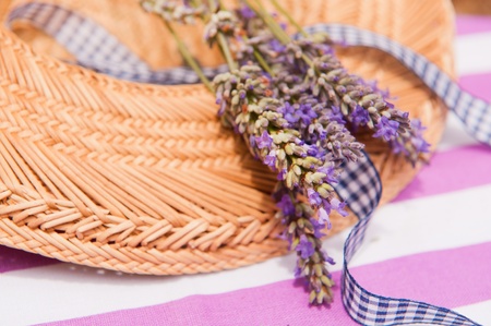 Detail of a straw summer hat with a bouzuet Lavender