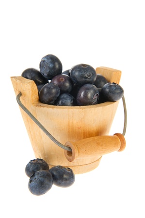 Wooden bucket full with fresh blueberries isolated over white backgroundの写真素材