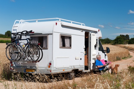 Man with dog on a trip with mobile homeの写真素材