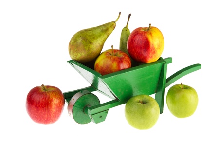 Apples and pears in wheel barrow isolated over white backgroundの写真素材