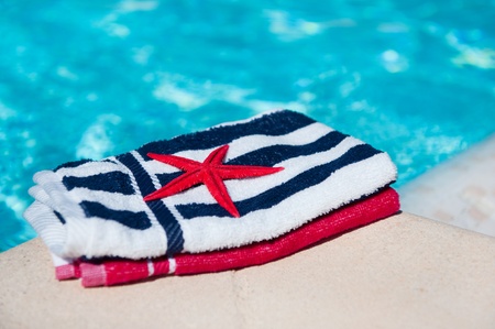 Folded towels and startfish near the swimming poolの写真素材