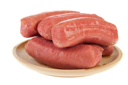 wooden plate with raw sausages isolated over white backgroundの写真素材