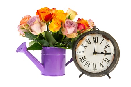 Bouquet colorful roses in watering can with vintaage clock isolated over white backgroundの写真素材
