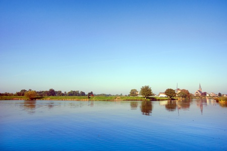 Small river with boat in Holland near the village Beesd