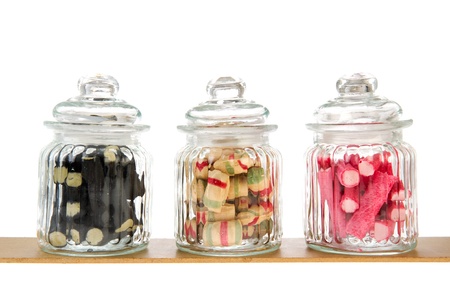 Three filled glass candy jars isolated over white backgroundの写真素材