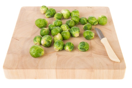 Brussels sprouts on wooden board with knifeの写真素材